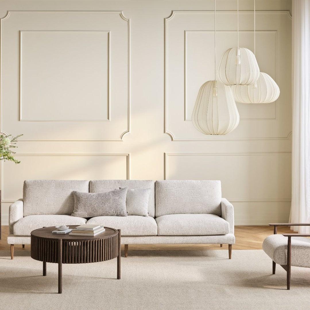 Light beige sofa with subtle texture, complementing patterned walls and a natural, neutral decor palette.