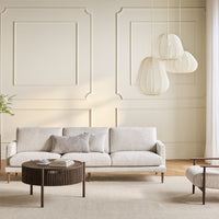 Light beige sofa with subtle texture, complementing patterned walls and a natural, neutral decor palette.