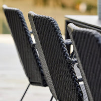 Black woven dining chairs with a sleek, modern design, featuring a textured pattern for added style.