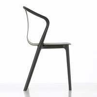 "Side view of a sleek black chair with a minimalist design and light gray seat, featuring smooth curves and clean lines."