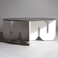 Modern round coffee table with a glossy white finish and unique curved cutout pattern. Ideal for contemporary decor.
