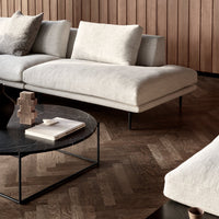 Light beige sectional sofa with textured fabric and sleek black metal legs, complemented by a dark marble coffee table.