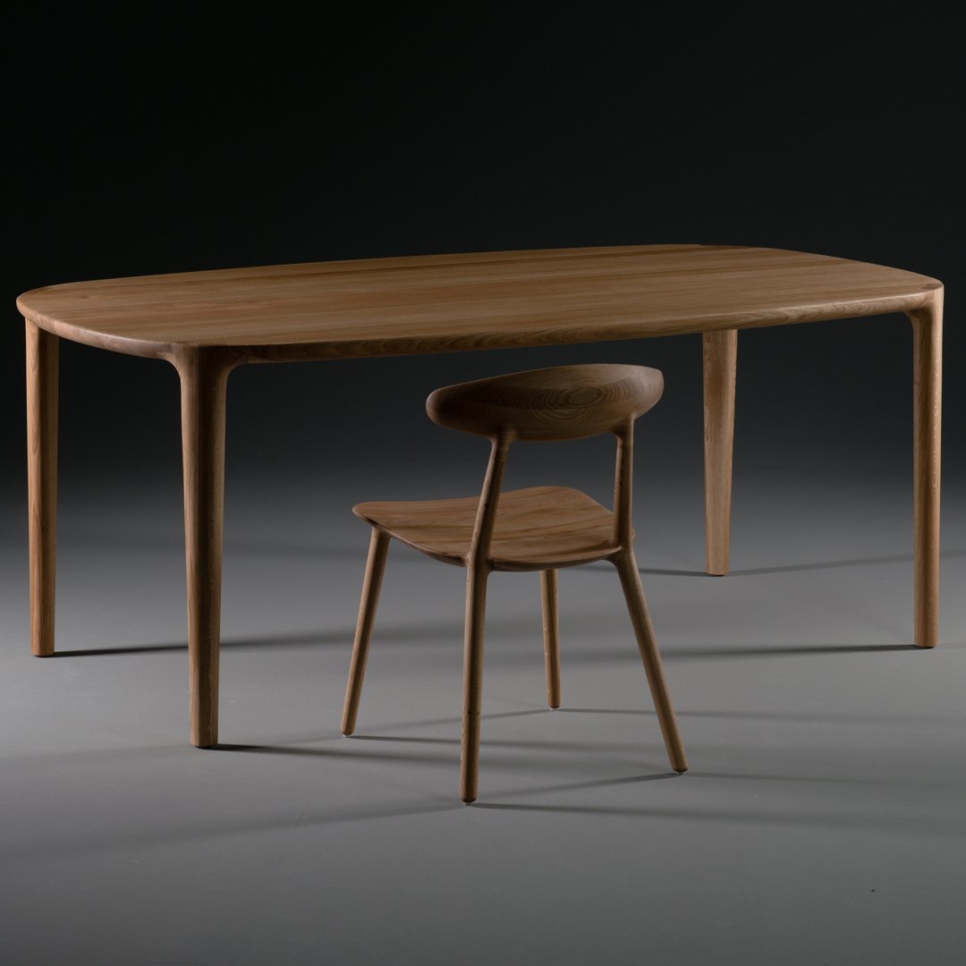 Wooden dining table and chair set with a natural finish, featuring smooth, rounded edges and a minimalist design.