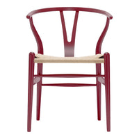 Red wooden chair with a distinctive Y-shaped back and natural woven seat, adding a modern touch to any space.