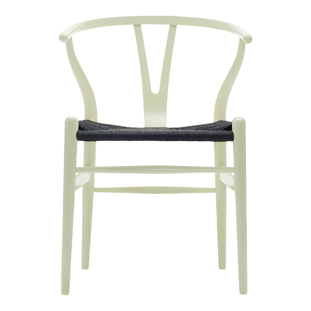 Light green chair with a sleek, minimalist design and a dark woven seat cushion. Perfect blend of color and texture.