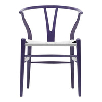 Purple chair with a unique Y-shaped back and neutral woven seat, showcasing modern design and vibrant color.