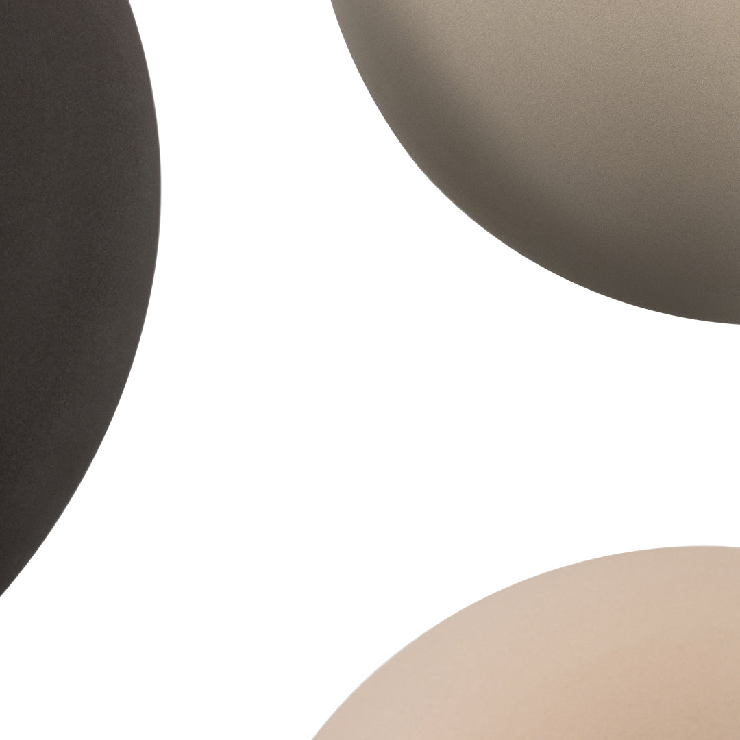 "Close-up of modern ceramic bowls in matte black, taupe, and soft beige colors with smooth, minimalistic design."