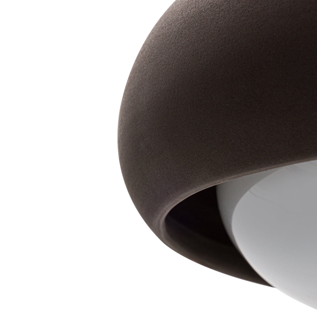 Brown curved shade with a smooth white interior, highlighting a modern, minimalist design.