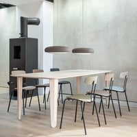 "Minimalist wooden dining table with pastel-colored chairs in muted tones against a modern, neutral backdrop."