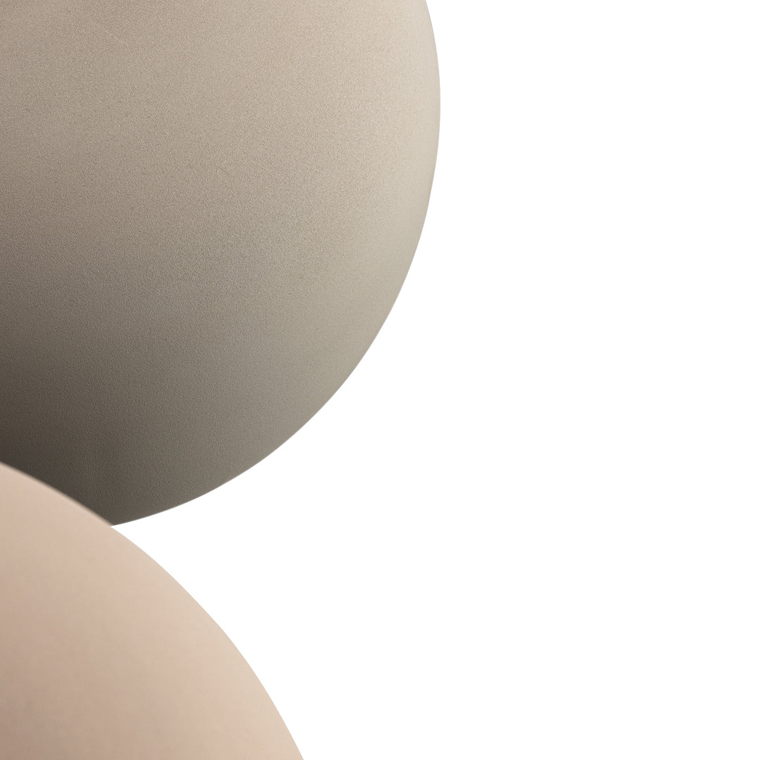 "Two smooth, rounded surfaces in soft beige and earthy taupe tones, showcasing subtle color variation."