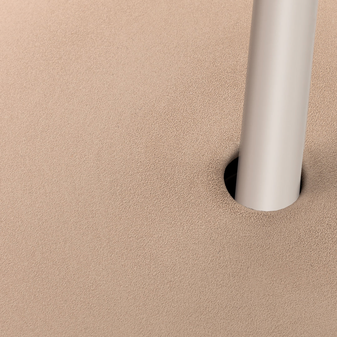 Beige textured surface with a sleek silver pole, featuring a minimalist design and smooth finish.