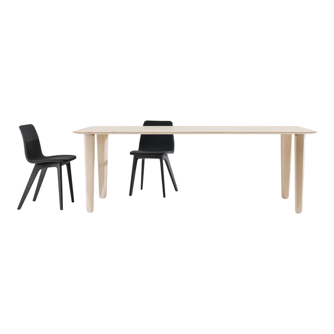 Modern wooden dining table in light natural finish paired with sleek black chairs for a stylish contrast.