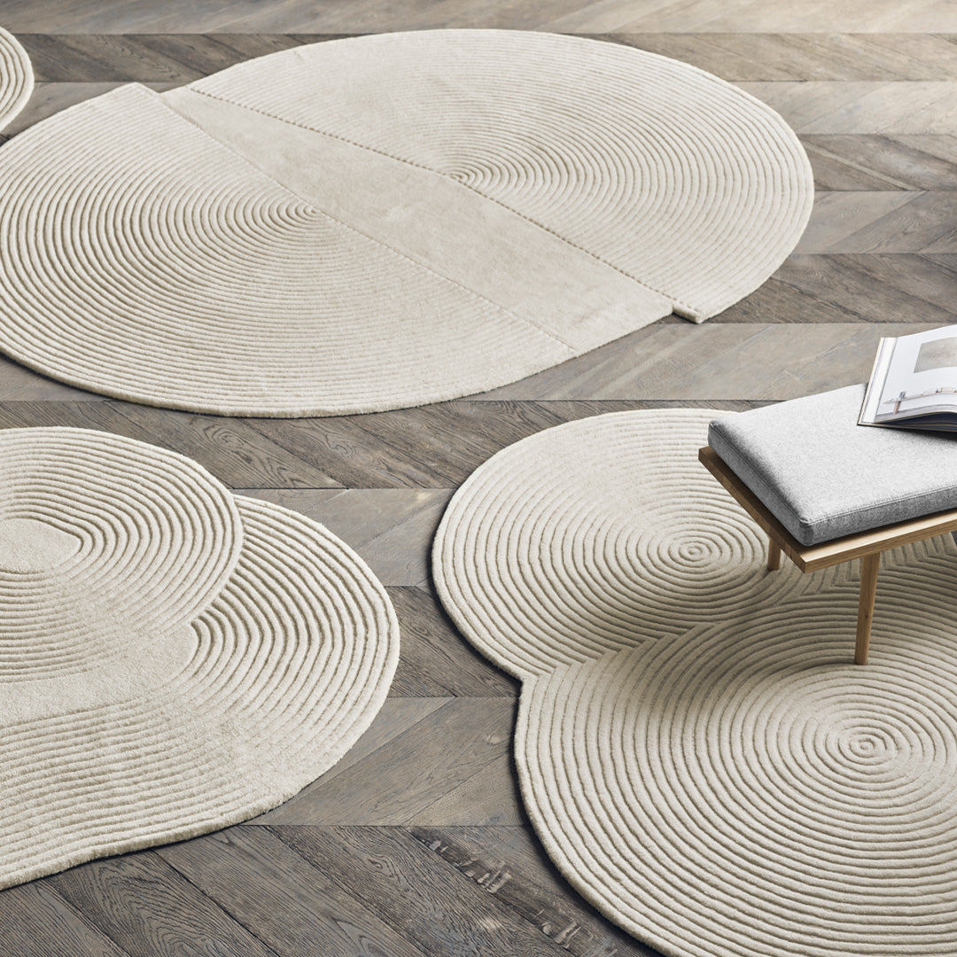 Beige area rugs with concentric circular patterns on a wooden floor. Stylish and modern for any decor.