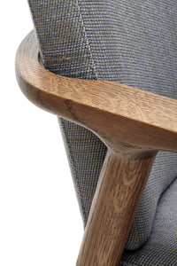 Gray patterned upholstery with natural wood accents enhancing a modern armchair design.