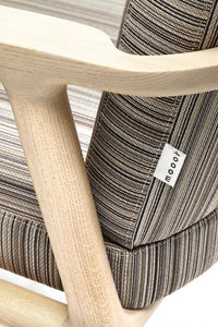 Multicolored striped upholstery with a blend of neutral tones on a modern wooden chair frame.